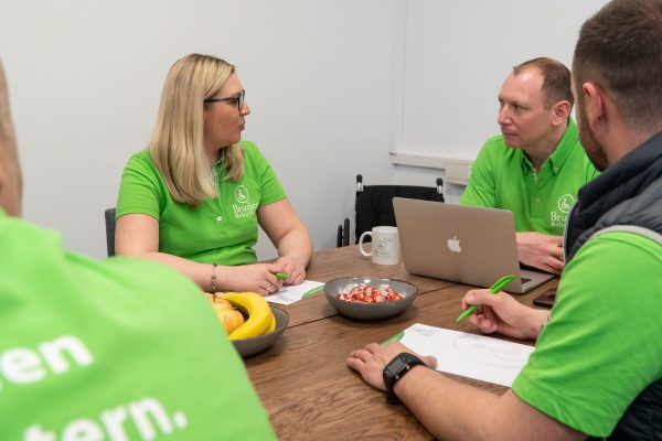 Mitarbeiter von Bruder RehaTech am Tisch sitzend besprechen sich im Büro