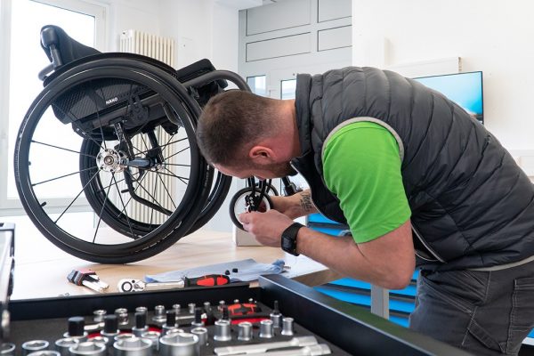 Mitarbeiter montiert Rollstuhl in Werkstatt von Bruder Rehatech